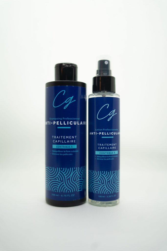 Produits de la Cure Anti-Pelliculaire CG sur fond neutre, incluant lotion et shampooing.